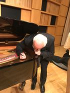 Julian Martin signs the inside of a piano