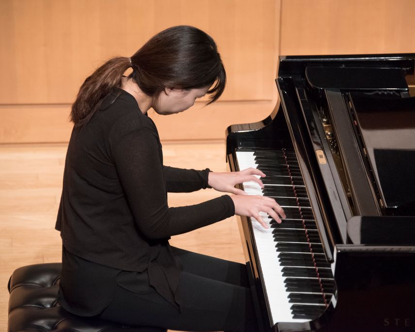 Cecelia Sakong plays piano on stage